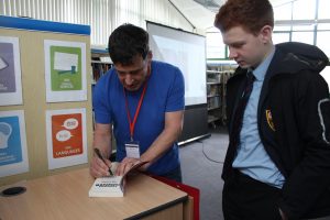 Student having booked signed by author Tom Palmer
